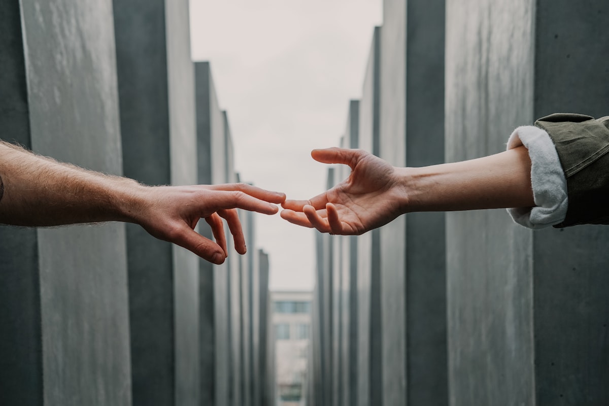 Two hands reaching toward one another, symbolizing support